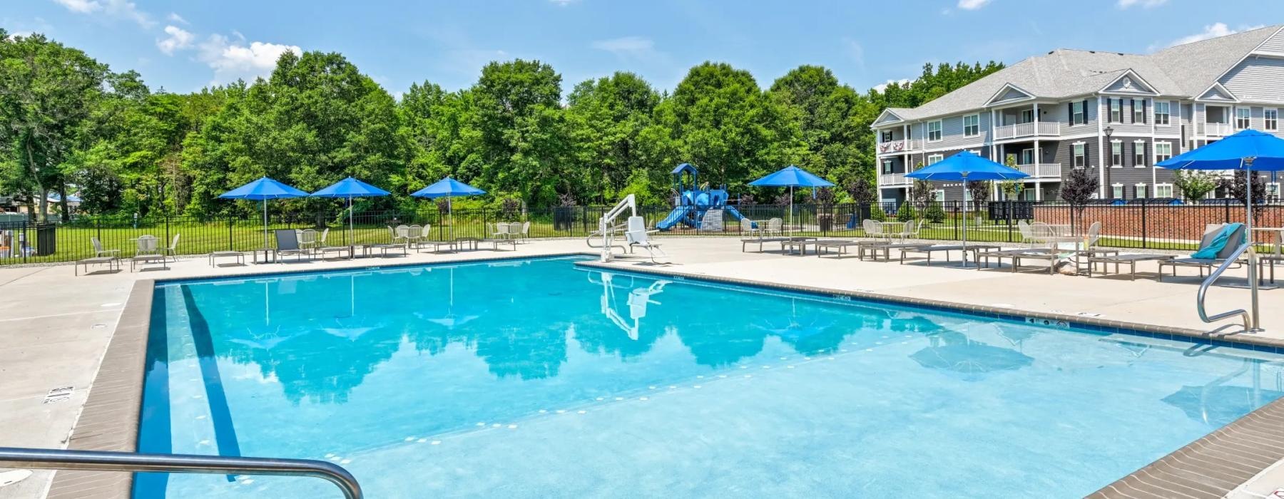 swimming pool surrounded by umbrella shaded lounge chairs